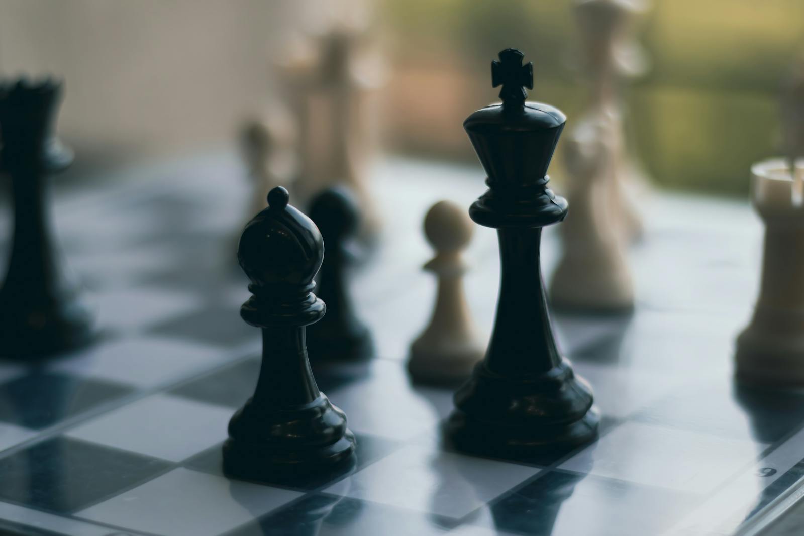 Close-up of chess pieces on a chessboard, emphasizing a strategic game setting.